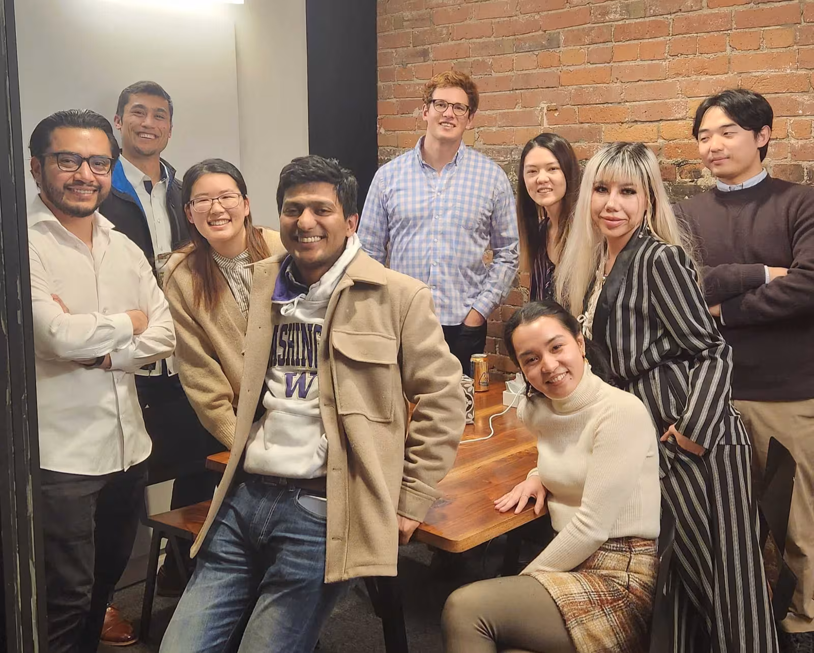 The Jia team gathered around a table in a brick-walled office, smiling at the camera